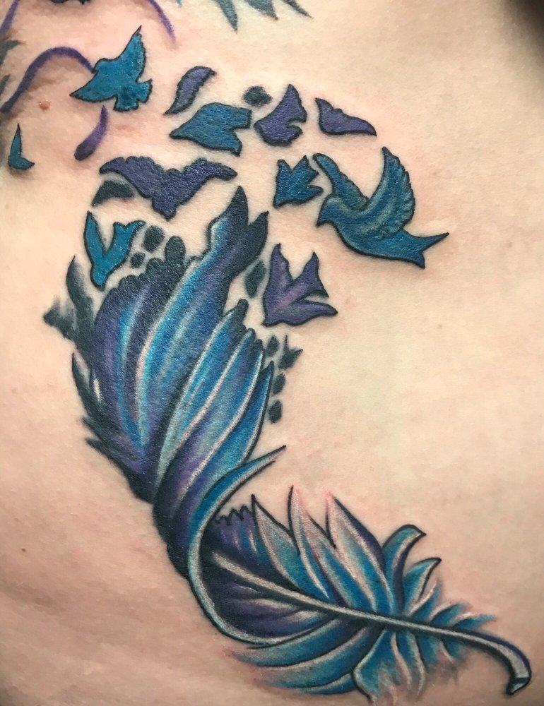 A blue and purple feather dissolving into a flock of small birds