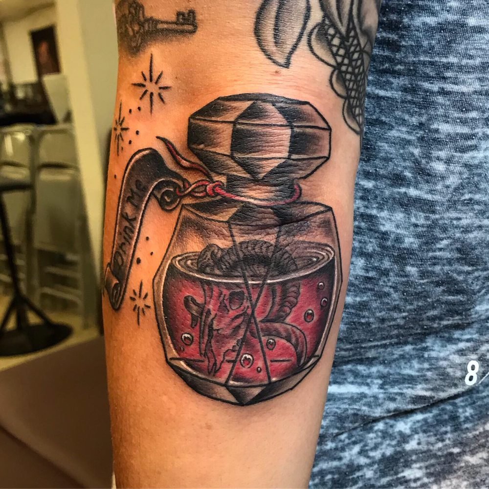 A traditional-style potion bottle with a skull in red liquid and a 'Drink me' tag