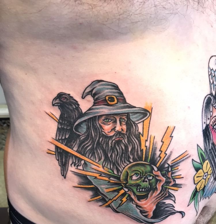 A traditional color wizard with a raven, lightning and a green skull on a side